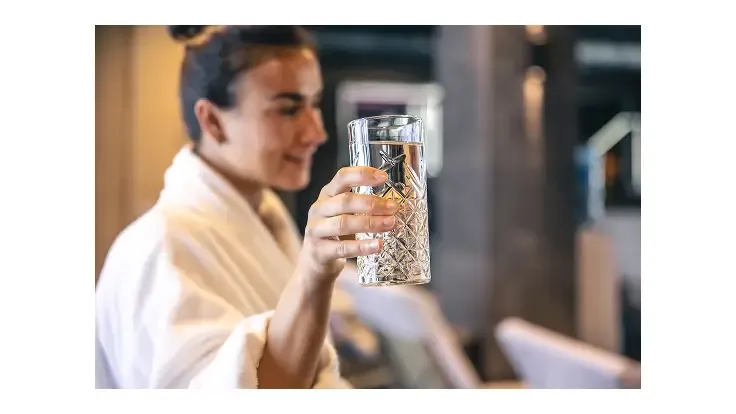 femeie-tinand-un-pahar-cu-apa-filtrata-prin-osmosa-inversa